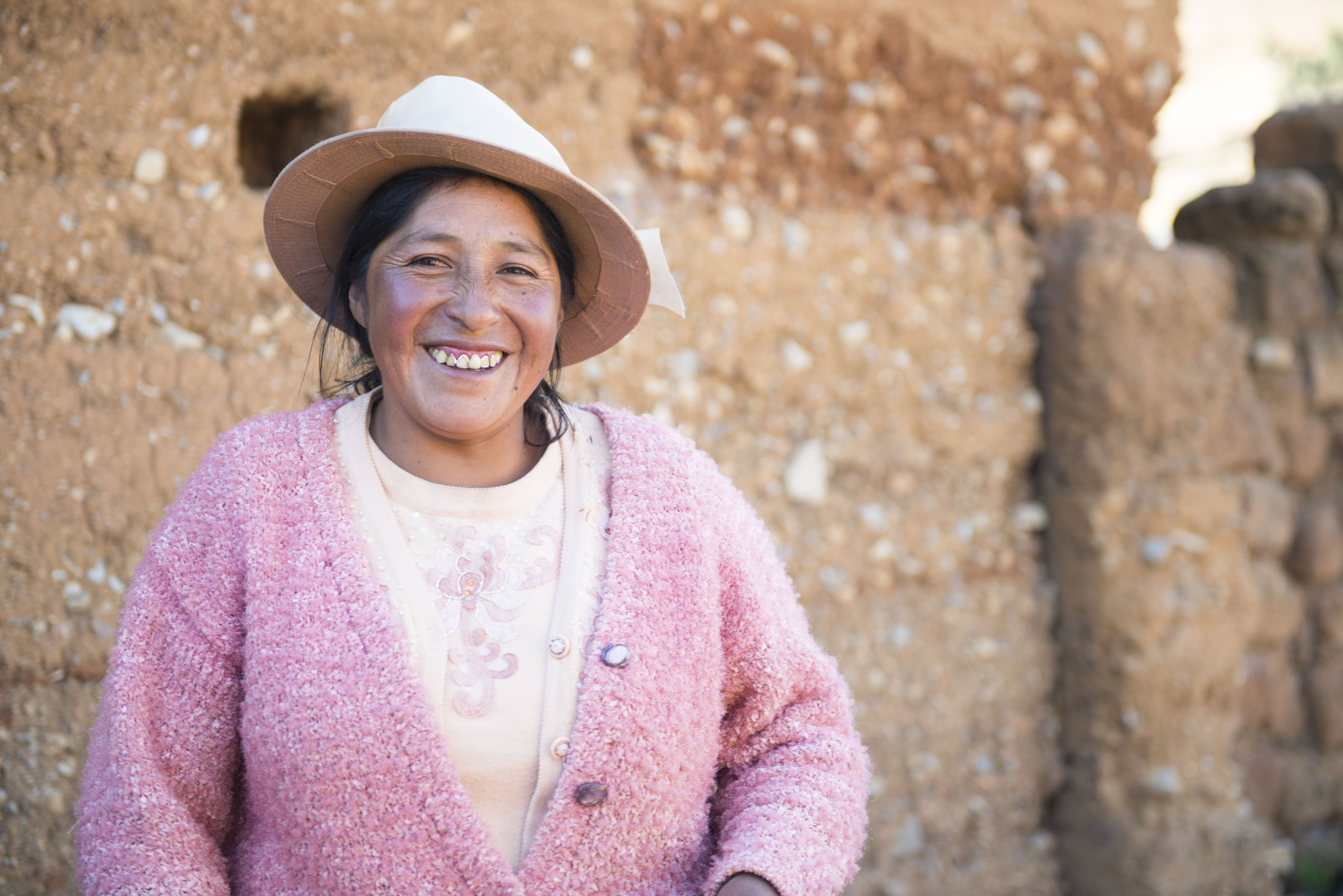 A Quechua woman smiles at the camera.